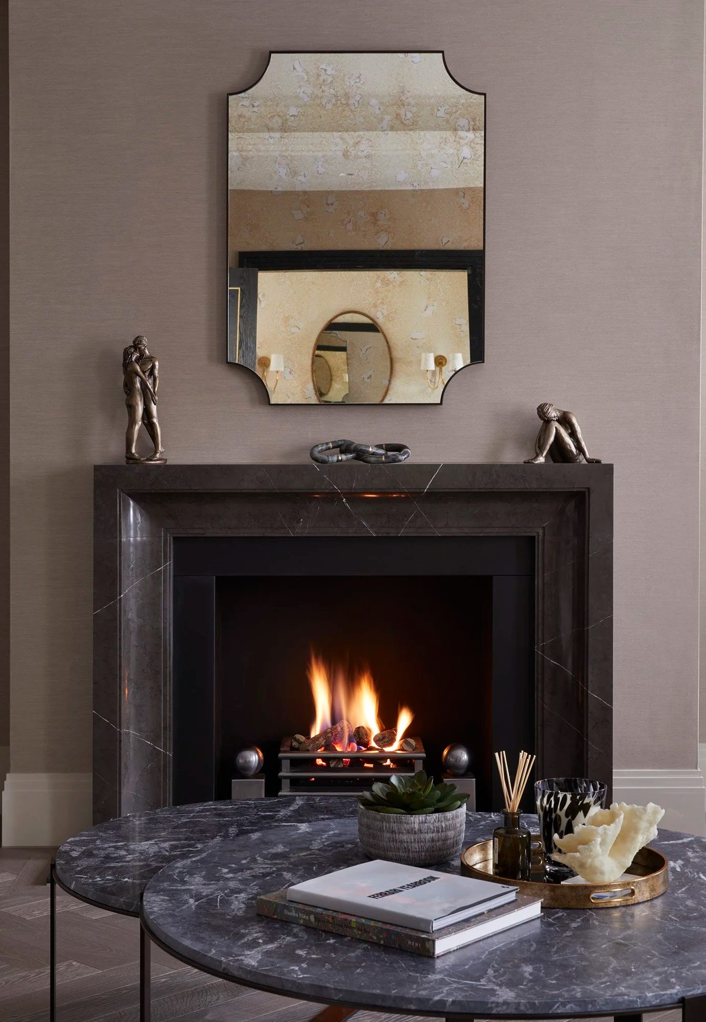 Marble fireplace with antique mirror and sculptural objects