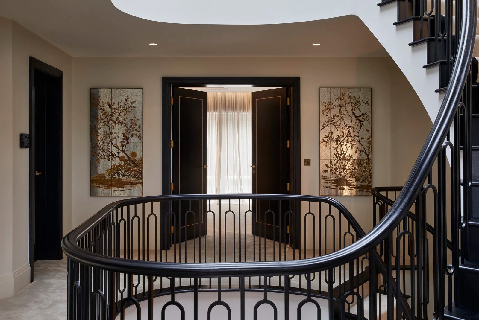 Curved staircase and hallway of a Katherine Varnava Interiors project