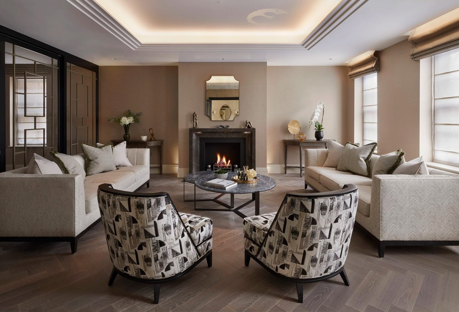 Living room with fireplace, twin sofas and patterned armchairs